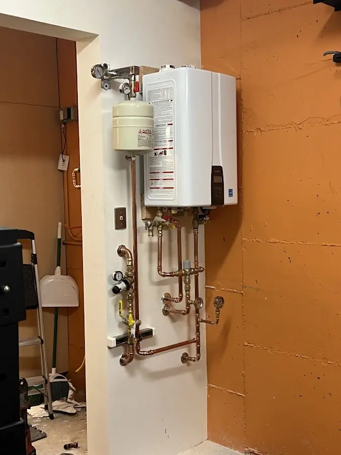 Plumbing technician inspecting water heater connections in Walkersville